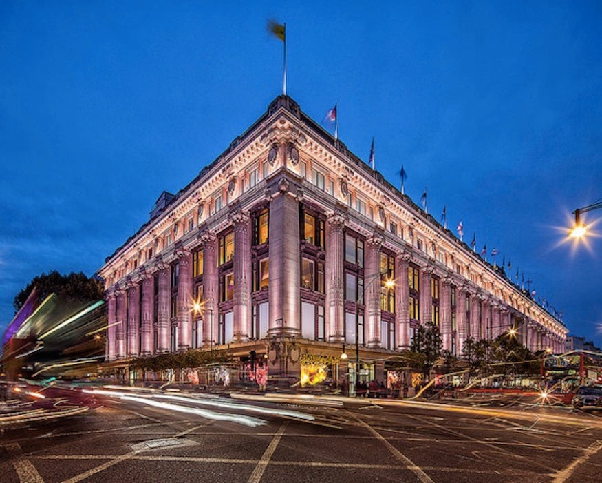 Large building illuminated at night with street lights and traffic.